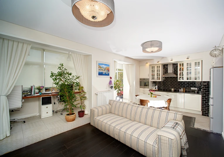 a nice looking living room with a striped couch and some potted plants