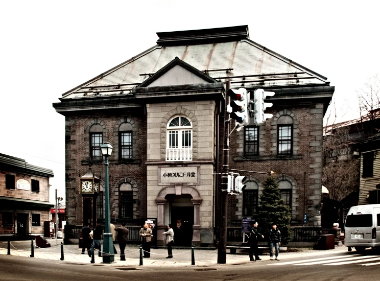 a group of people standing in front of a building on the side of a road