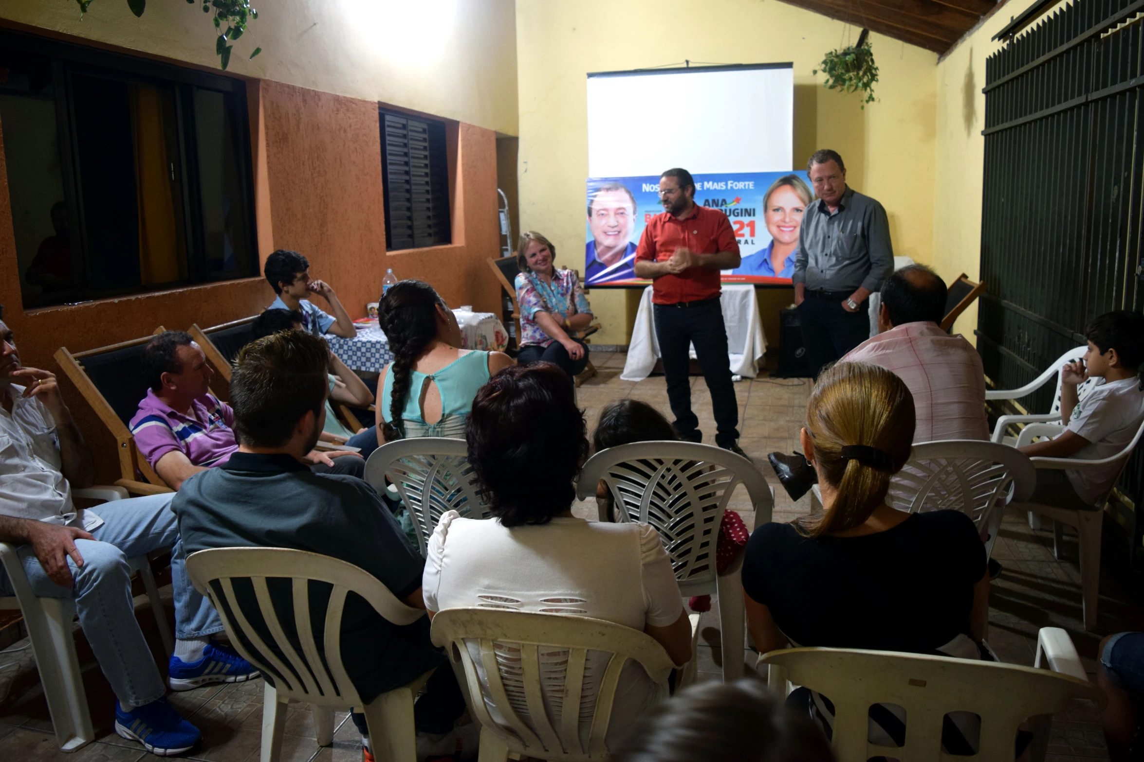 people sitting and standing around a room, listening to one another