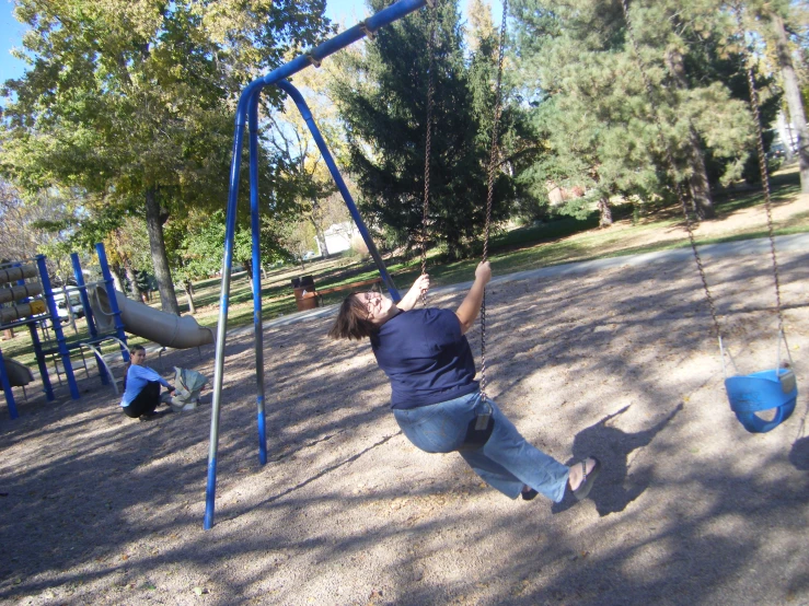 a woman on a swing set playing in the playground