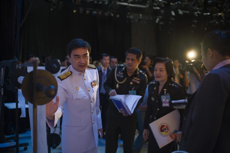 a group of men standing around a woman in uniform