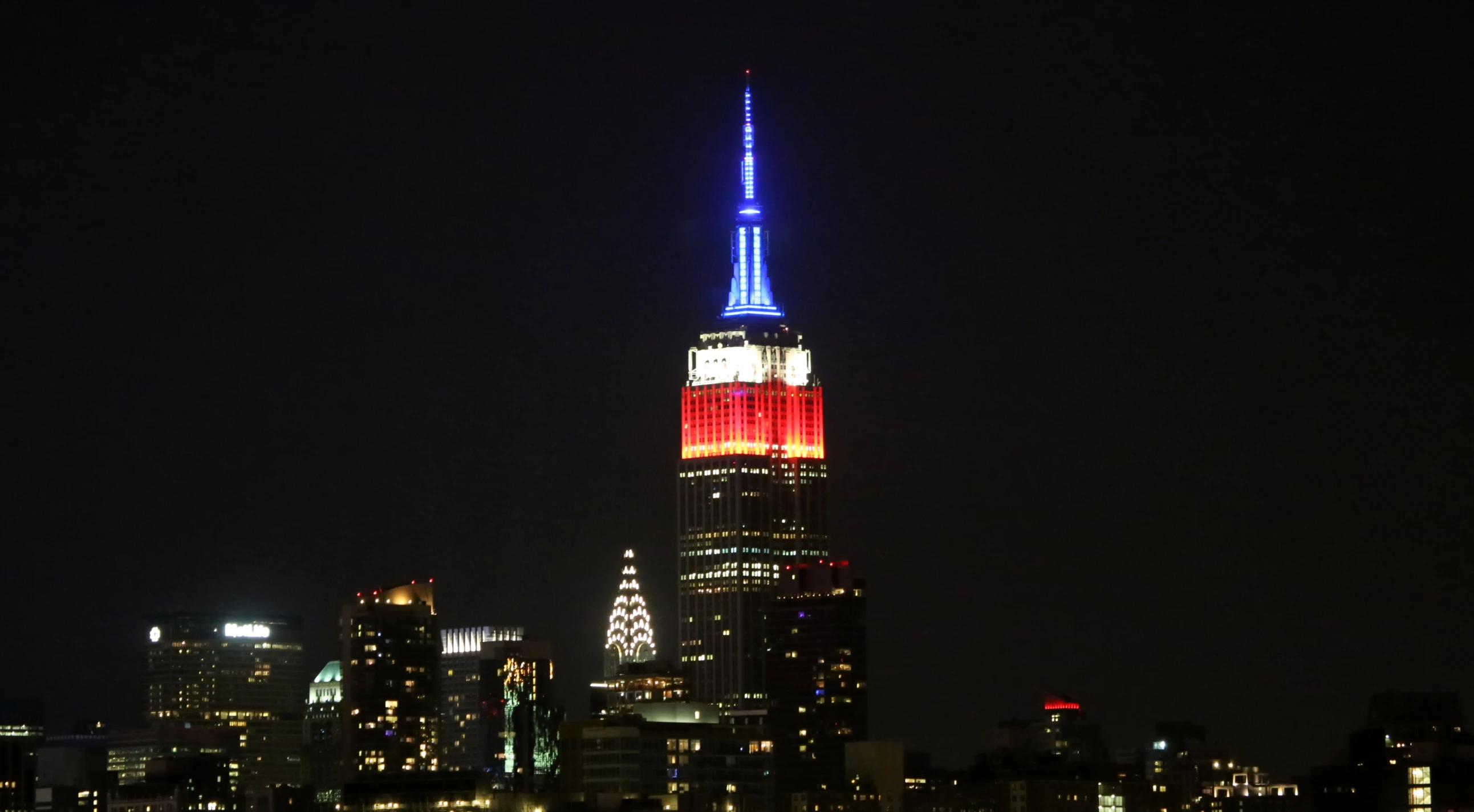 the empire state building lit up in red, white and blue