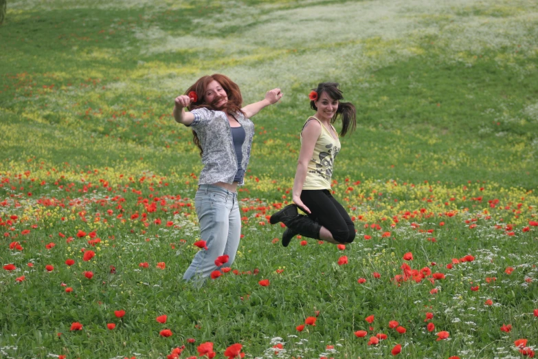two women posing in the middle of a field with flowers