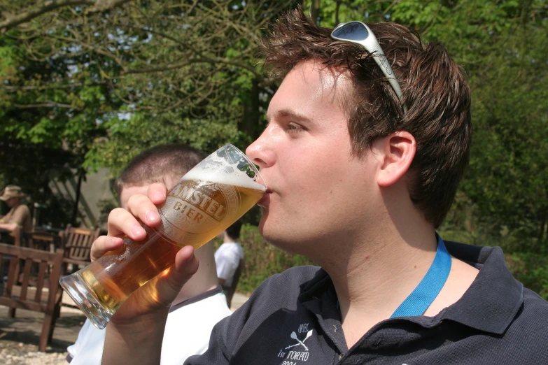 a man drinking beer out of a glass
