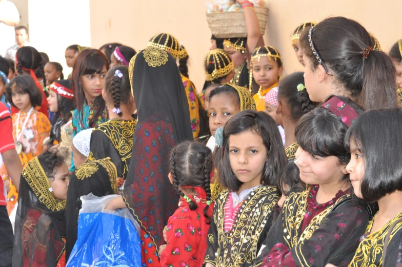 a group of girls dressed in various ethnic costumes and head scarves