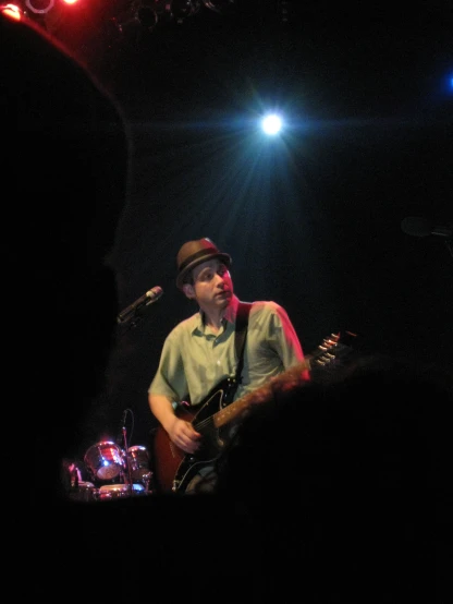 a man plays his guitar in front of the crowd