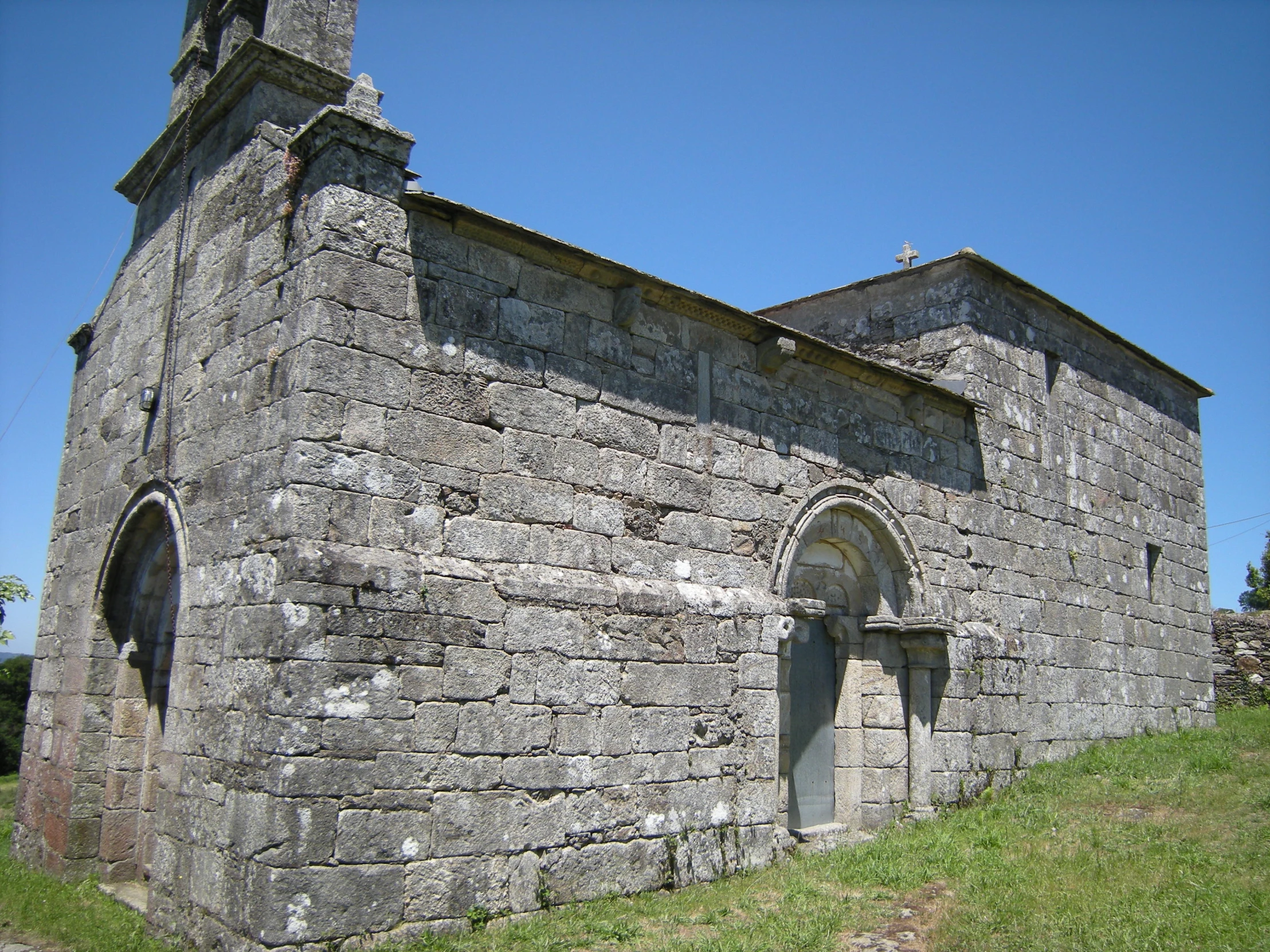 a building made of concrete with a stone top and a bell tower on the top of it