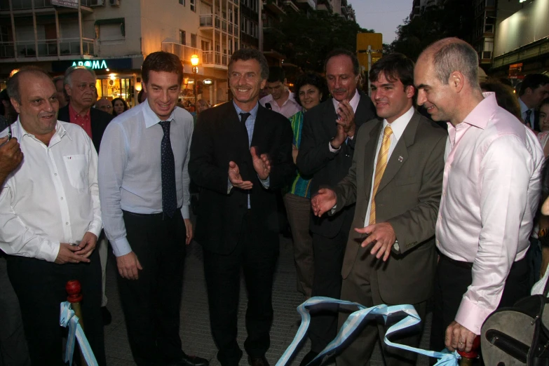 several men are meeting and smiling in front of an audience