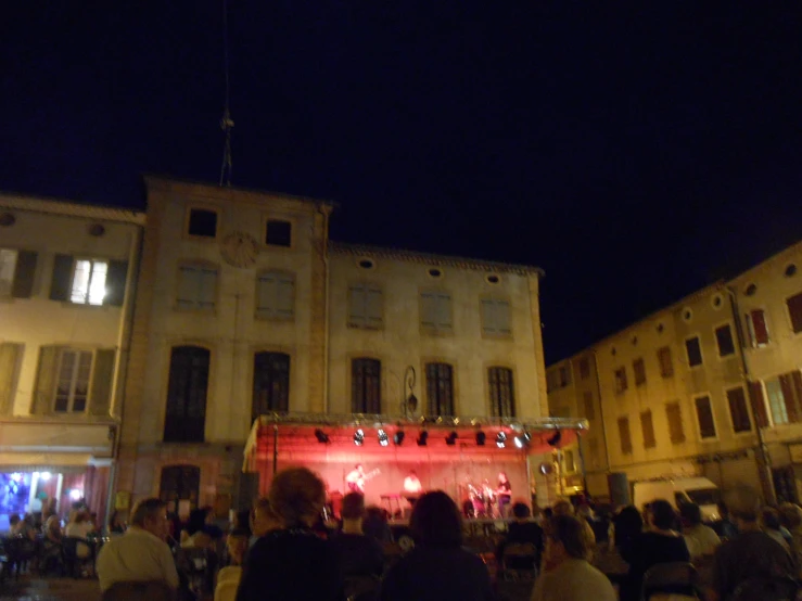 large group of people gathered in front of buildings on stage