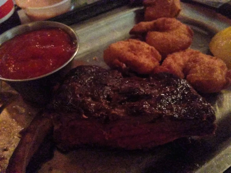 a plate with meat and tater tots and sauce on it