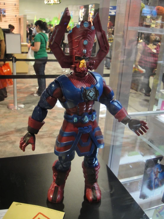 an iron man action figure posed in front of glass case