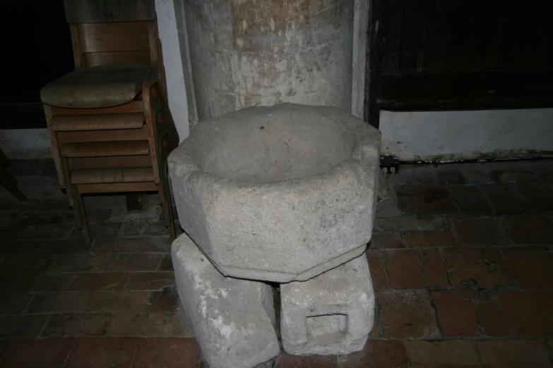 a stone statue of an infant sitting in a corner