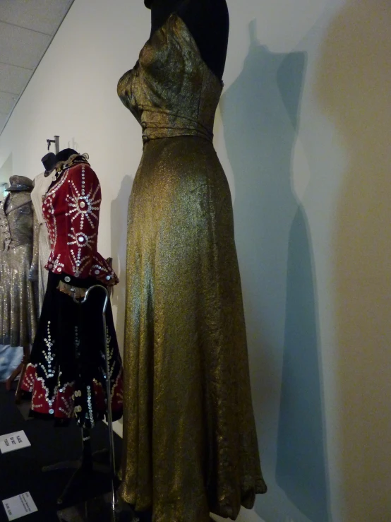 mannequin with a gold dress on display in a room