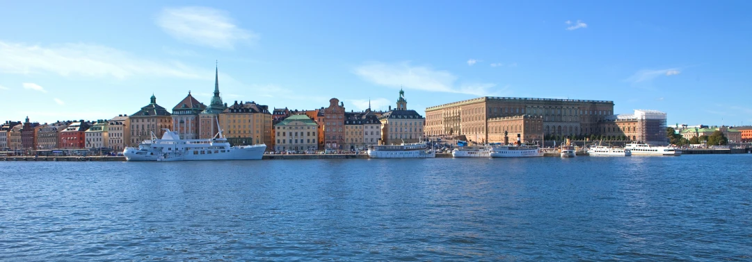 several ships docked on a river and city skyline