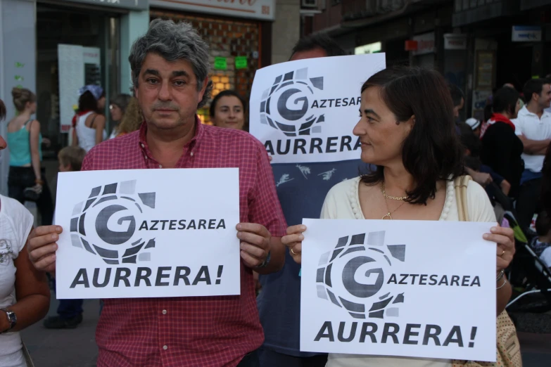 a man and woman holding up white signs