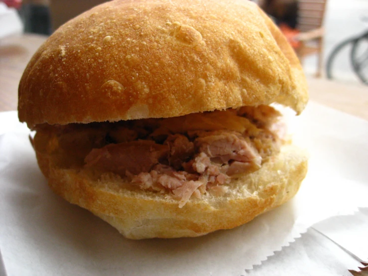 a close up of a sandwich that is on wax paper