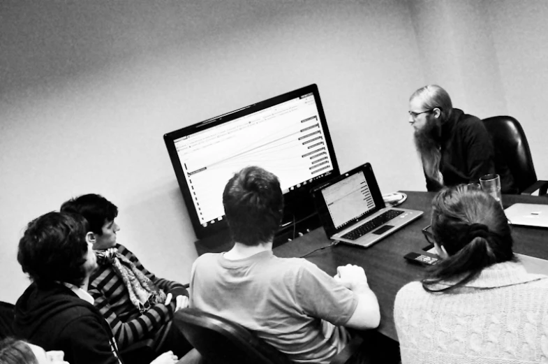 a group of people looking at a computer screen