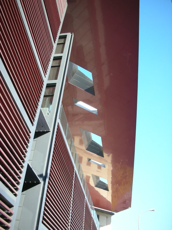 the side of an apartment building with a red wall and several balconies