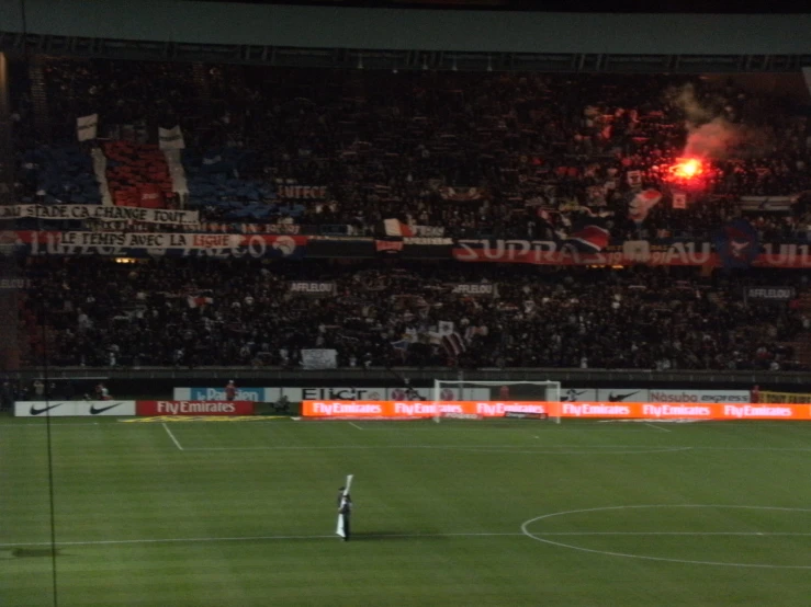 a soccer player running on the field in front of a crowd