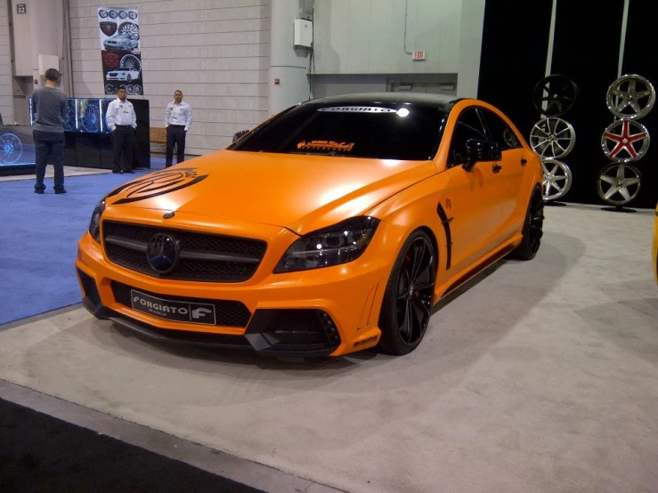 a bright orange sports car sitting on display