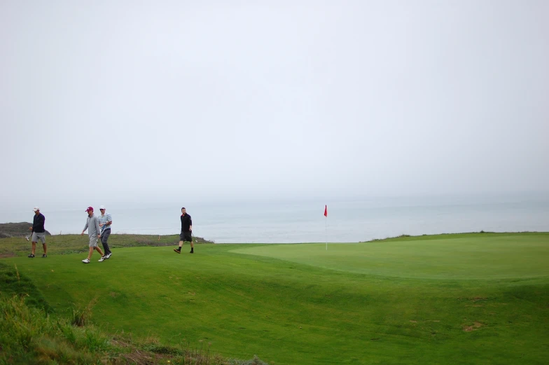 people are playing golf on a foggy day