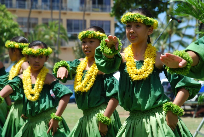 a group of s dressed in green and yellow hula skirts