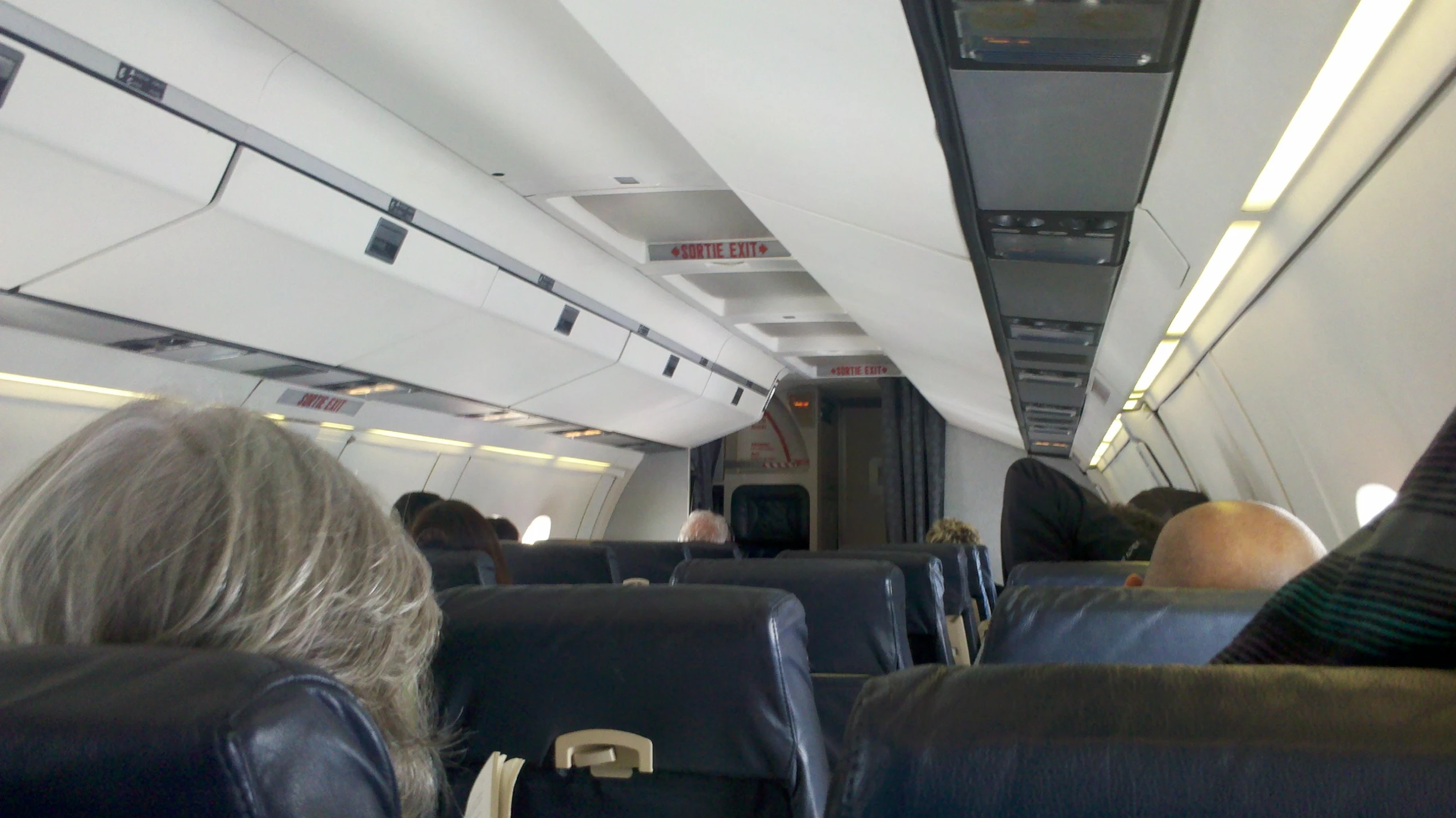 passengers sitting on a passenger airplane with seats down