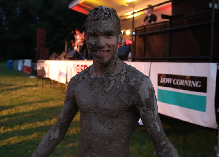 a young man is covered with mud at a festival