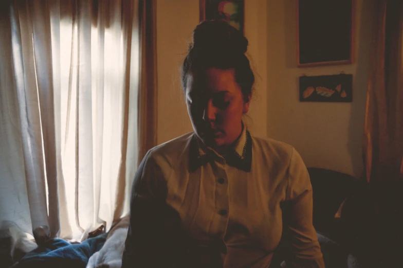 a woman with a bow tie in a dark room