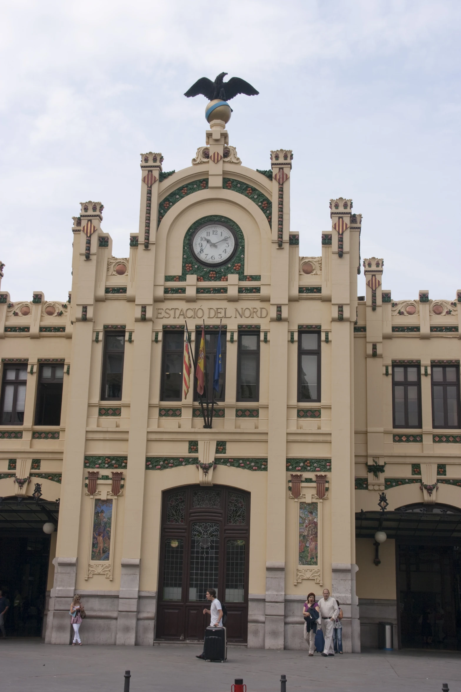 two people and a clock on top of a building