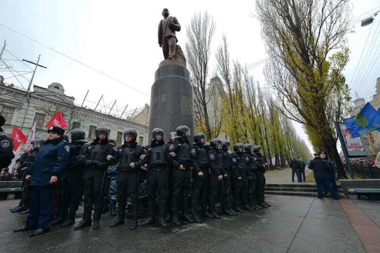 some police officers standing in front of a monument with an old statue