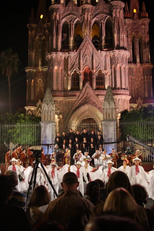 an ensemble performing in front of a church