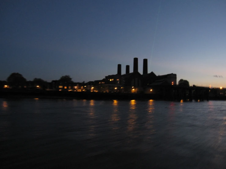 a large factory near a harbor in the evening