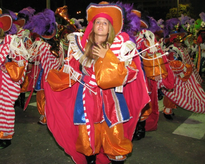 a woman in bright dress and headpiece with colorful costume walking on the road