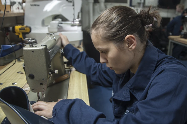 a woman is using an old sewing machine