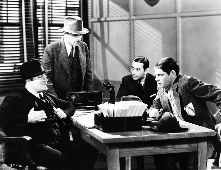 five men are around a table dressed up