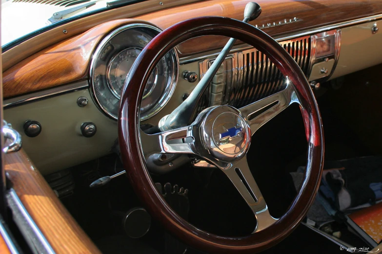 a car dashboard with a steering wheel and the center piece with wood grained trim