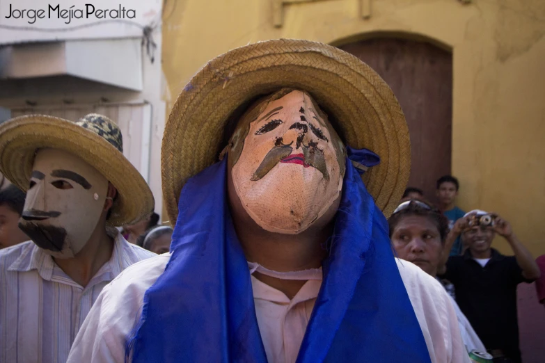 people with painted faces on their faces in blue scarves