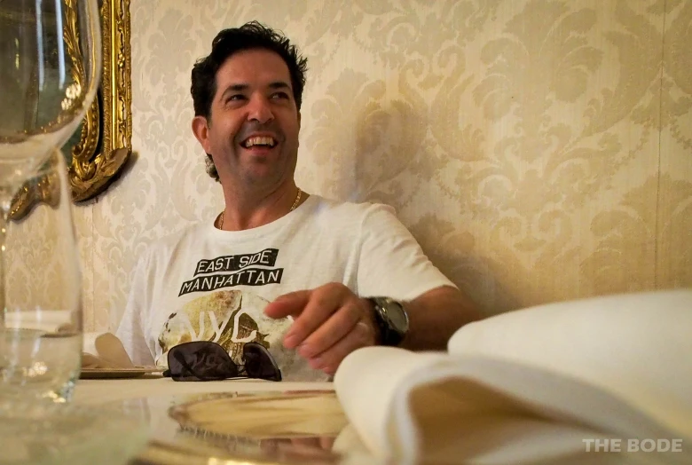 a man holding onto some desserts at a table