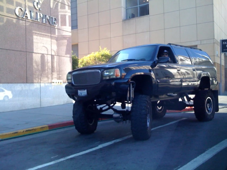 a large black truck parked on the side of a road