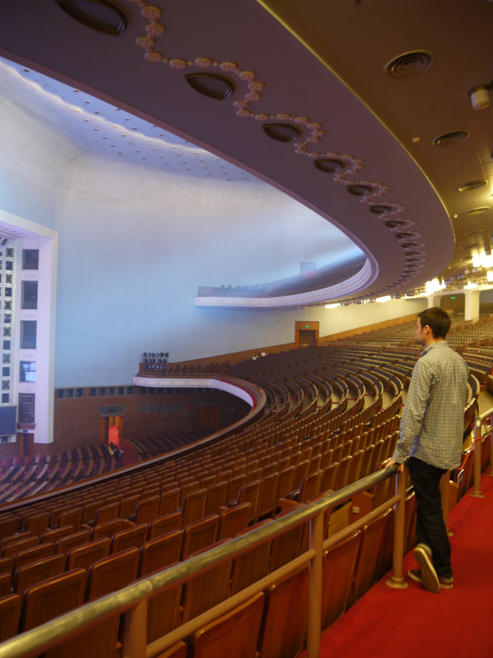 a man is standing at the stage in a large auditorium