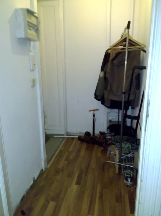 a very small closet that has some clothes on it