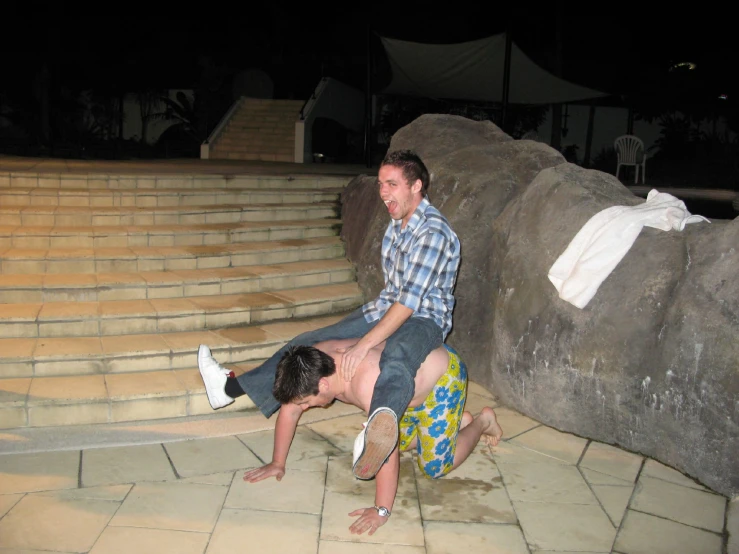 two people sitting on stairs and one is touching his head