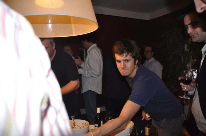 people at a bar having a drink and a man holding a plate