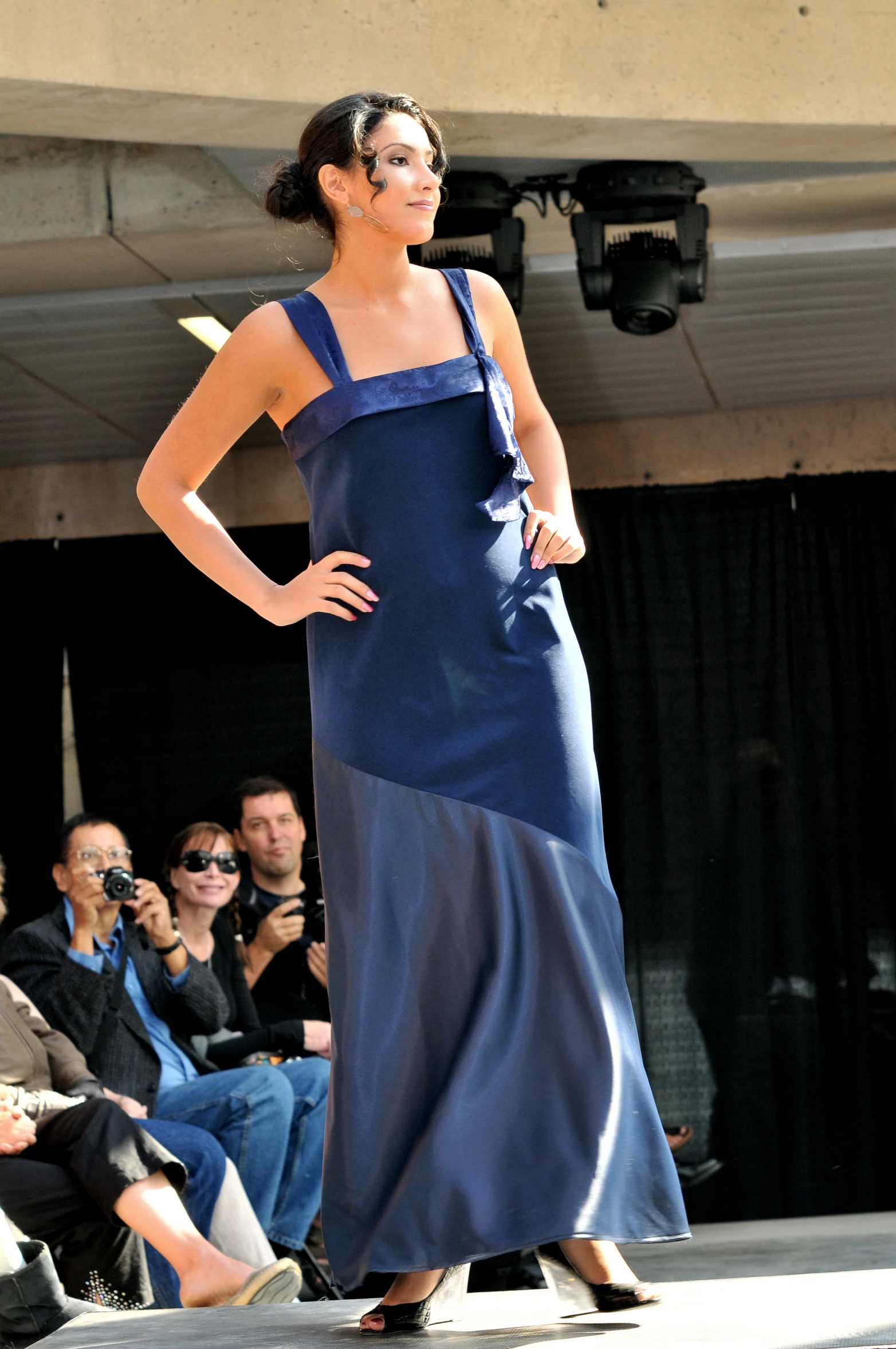 a model wearing a long blue dress on a runway