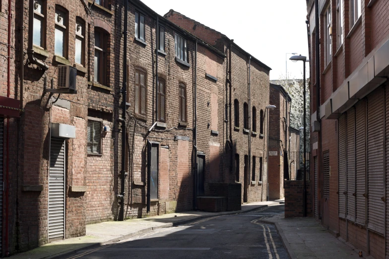 a deserted street lined with tall brick buildings