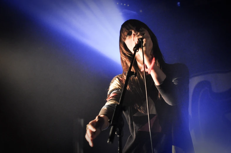 a woman singing into a microphone on stage