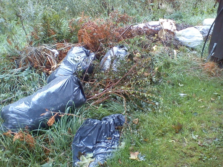 garbage bags are sitting outside of a fence