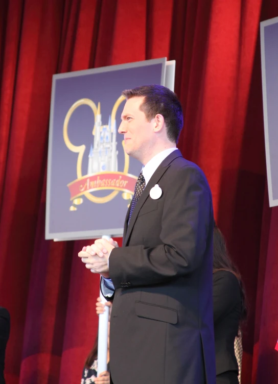 a man standing on a stage in a suit