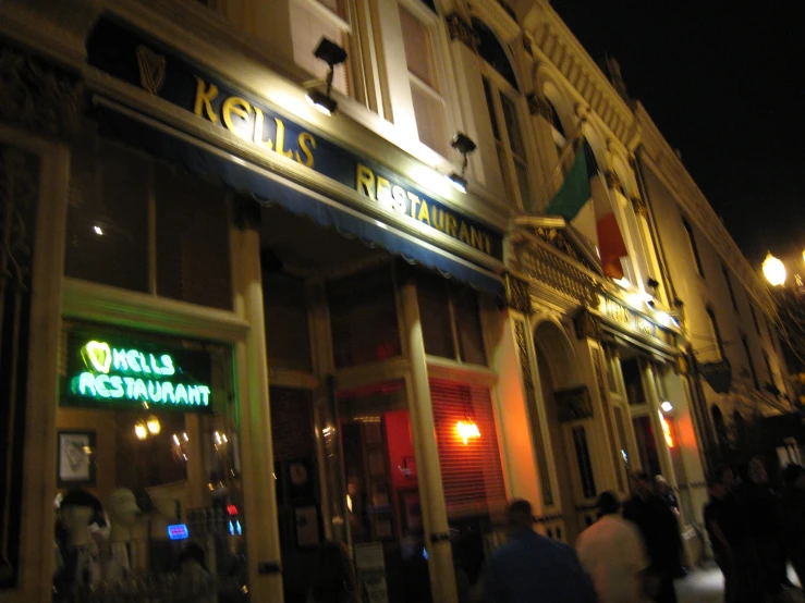 people are standing in front of a building at night